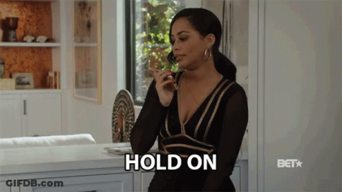 A Woman In A Black And Gold Dress Is Talking On A Cell Phone And The Word Hold On Is Visible GIF