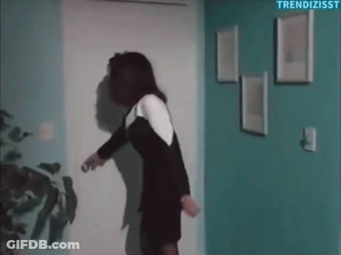 Woman In Black And White Dress Holding Door Open GIF