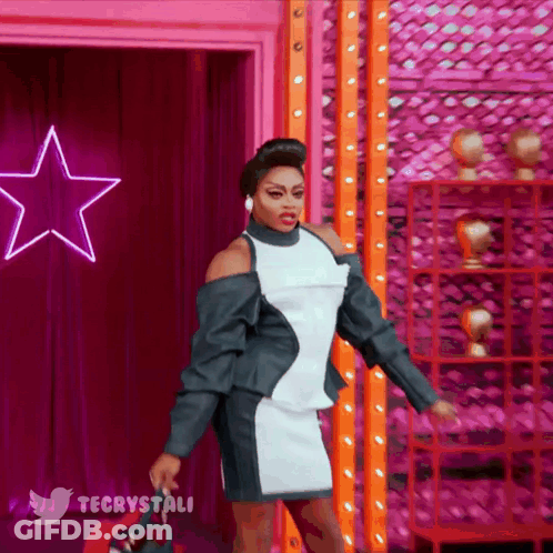 Woman In Black And White Dress In Front Of Pink Star And Twitter Logo GIF