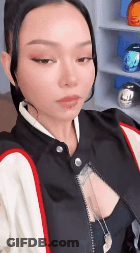 A Woman In A Black And White Jacket Is Taking A Picture Of Herself . GIF