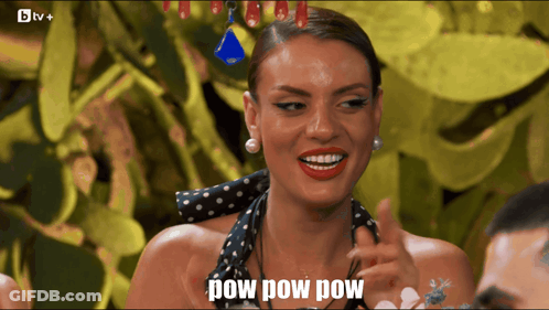 A Woman In A Black And White Polka Dot Dress Is Smiling And Says Pow Pow Pow GIF