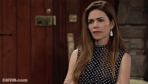 A Woman In A Black And White Polka Dot Top Is Making A Face GIF
