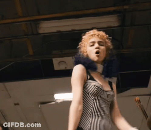 A Woman In A Black And White Striped Dress Singing GIF