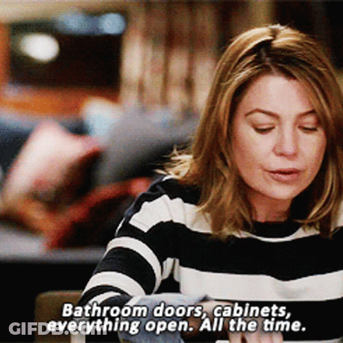 Woman In Striped Sweater Says Bathroom Doors Cabinets Always Open GIF