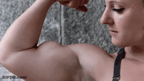A Woman In A Black Bra Flexes Her Biceps GIF