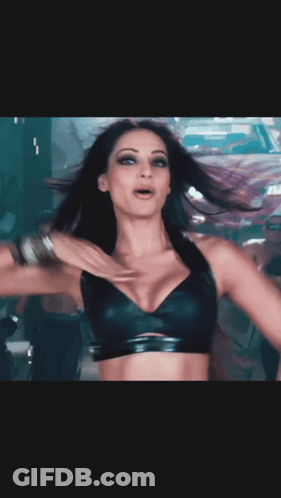A Woman In A Black Bra Is Dancing In Front Of A White And Red Car GIF