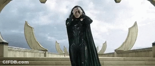 A Woman In A Black Cape Is Standing On Top Of A Set Of Stairs . GIF