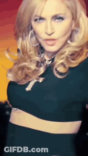 A Woman In A Black Crop Top Has A Cross On Her Chest GIF