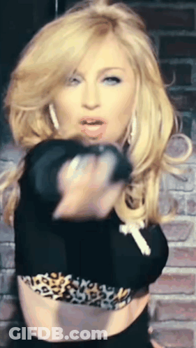 A Woman In A Black Crop Top With A Leopard Print Is Pointing At The Camera GIF