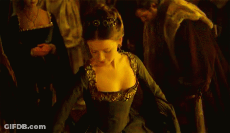 A Woman In A Black Dress Is Dancing In Front Of A Crowd GIF