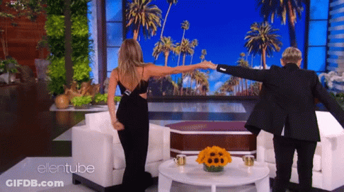 A Woman In A Black Dress Is Dancing With A Man In A Black Suit On The Ellentube Show GIF