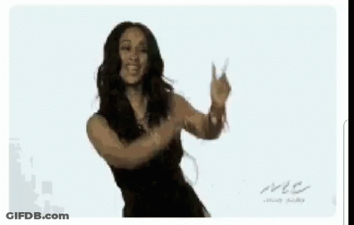 A Woman In A Black Dress Is Dancing With Her Arms Outstretched GIF