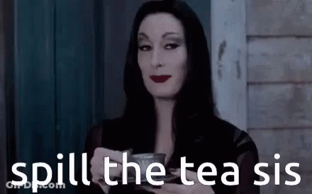 A Woman In A Black Dress Is Holding A Cup Of Tea . GIF