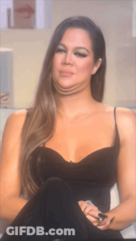 A Woman In A Black Dress Is Making A Funny Face With Her Mouth Open GIF