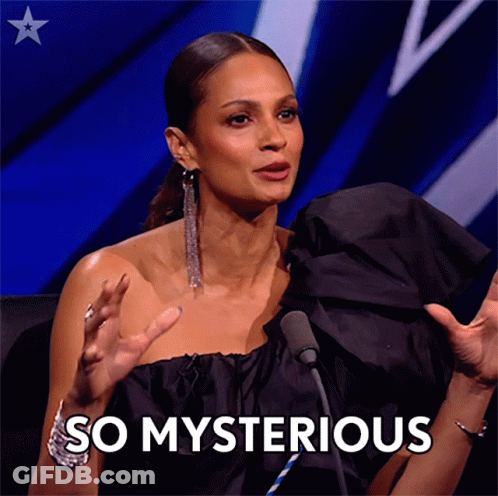 A Woman In A Black Dress Is Sitting In Front Of A Microphone And Says " So Mysterious " GIF