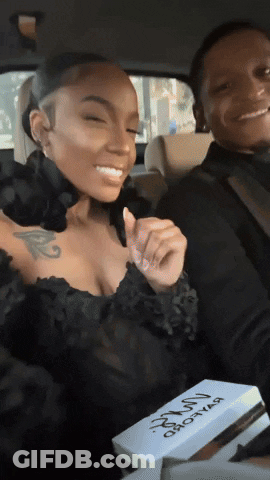 A Woman In A Black Dress Is Sitting Next To A Man In A Car Holding A Box That Says ' Hot Girl ' GIF