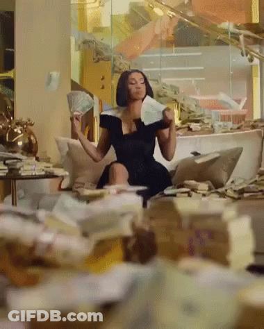 A Woman In A Black Dress Is Sitting On A Couch Holding Money GIF
