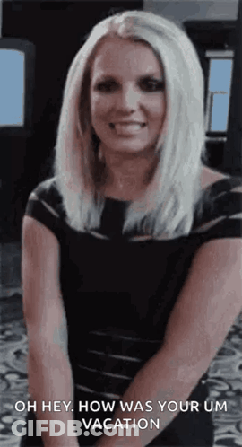 A Woman In A Black Dress Is Smiling And Saying Oh Hey How Was Your Um Vacation GIF