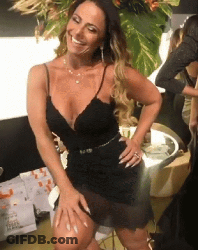 A Woman In A Black Dress Is Smiling With A License Plate That Says L9849 GIF