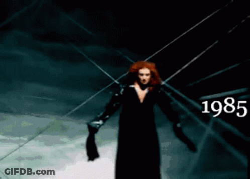 Woman In Black Dress Standing In Dark Room 1985 GIF