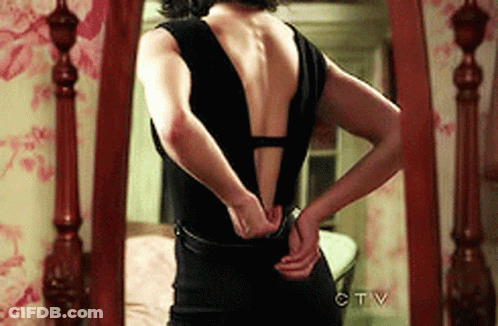 A Woman In A Black Dress Is Standing In Front Of A Mirror That Says Ctv On The Bottom GIF