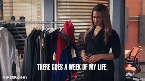 A Woman In A Black Dress Is Standing In Front Of A Rack Of Clothes And Says " There Goes A Week Of My Life " GIF