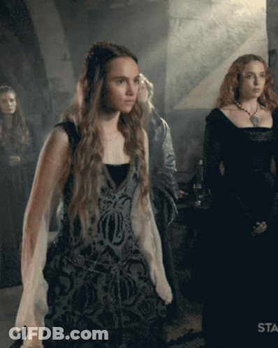 A Woman In A Black Dress Is Standing Next To A Woman In A White Dress GIF