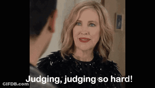 A Woman In A Black Dress Is Talking To A Man And Saying Judging , Judging So Hard . GIF