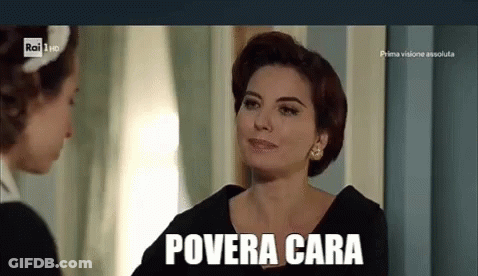 A Woman In A Black Dress Is Talking To Another Woman In A Room And The Woman Is Smiling . GIF