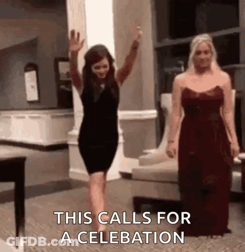 A Woman In A Black Dress Is Waving Her Hand While Another Woman In A Red Dress Is Standing Next To Her . GIF