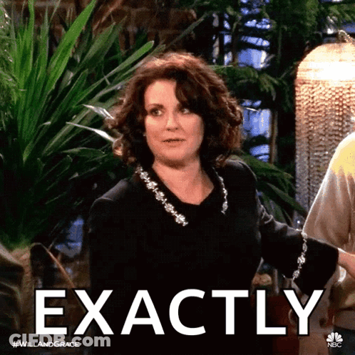 A Woman In A Black Dress Says Exactly In Front Of A Greenhouse GIF