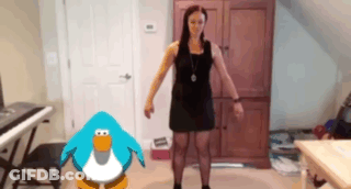 A Woman In A Black Dress Stands Next To A Penguin GIF
