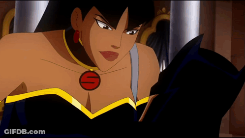 A Woman In A Black Dress With A Red S On Her Chest Is Reading A Book GIF