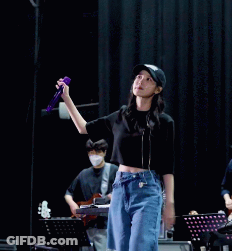 A Woman In A Black Hat Holds A Purple Microphone GIF