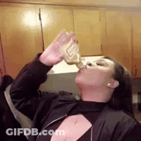 A Woman In A Black Jacket Is Drinking From A Bottle Of Beer . GIF