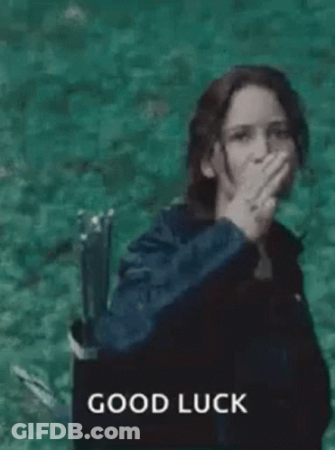 A Woman In A Black Jacket Is Giving A High Five In Front Of A Body Of Water . GIF