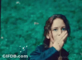 A Woman In A Black Jacket Is Giving A Peace Sign GIF