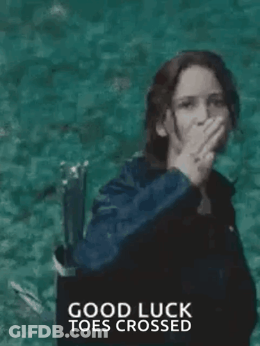 A Woman In A Black Jacket Is Giving The Middle Finger While Standing In Front Of A Body Of Water . GIF