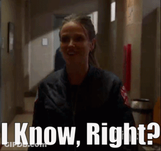 A Woman In A Black Jacket Is Standing In A Hallway And Says I Know Right . GIF