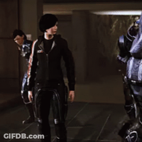 A Woman In A Black Jacket Is Standing In Front Of A Robot GIF