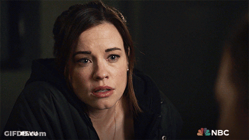 A Woman In A Black Jacket With The Nbc Logo Behind Her GIF