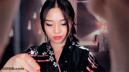 A Woman In A Black Kimono With Flowers On It GIF