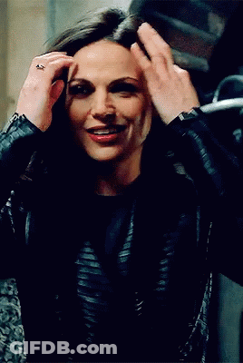 A Woman In A Black Leather Jacket Holds Her Hair Up GIF