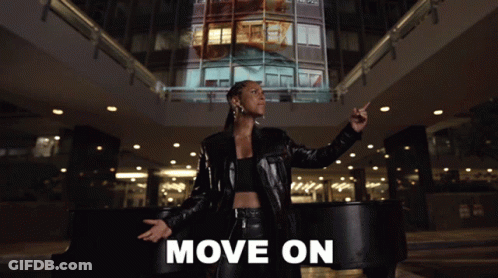 A Woman In A Black Leather Jacket Stands In Front Of A Piano With The Words Move On Written Below Her GIF