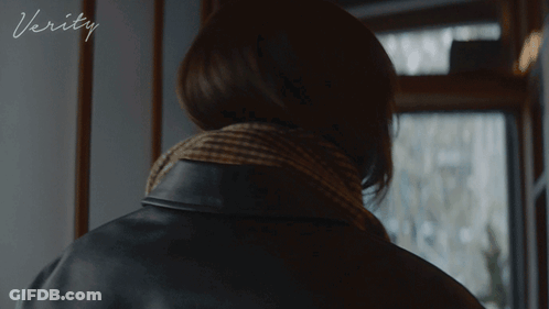 A Woman In A Black Leather Jacket With The Word Verity On The Bottom Right GIF