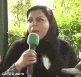A Woman In A Black Scarf Is Holding A Green Microphone In Her Mouth . GIF