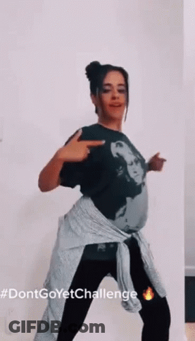 A Woman In A Black Shirt And Black Pants Is Dancing . GIF