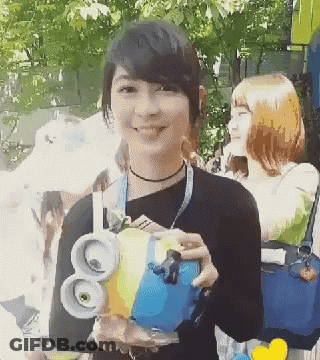 A Woman In A Black Shirt Is Holding A Blue And Yellow Object With The Number 80 On It GIF