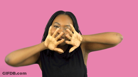 A Woman In A Black Shirt Is Making A Face With Her Hands GIF
