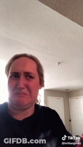 A Woman In A Black Shirt Is Making A Funny Face In A Tiktok Video . GIF